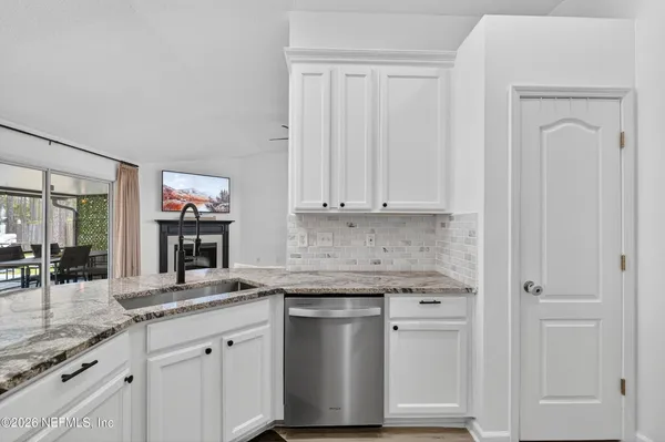 a kitchen with stainless steel appliances granite countertop white cabinets and a granite counter tops
