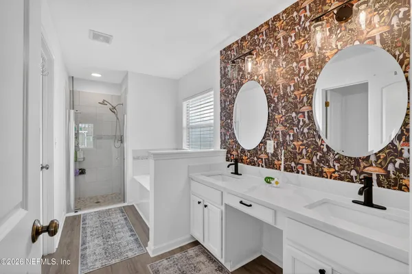 a bathroom with a double vanity sink mirror and shower