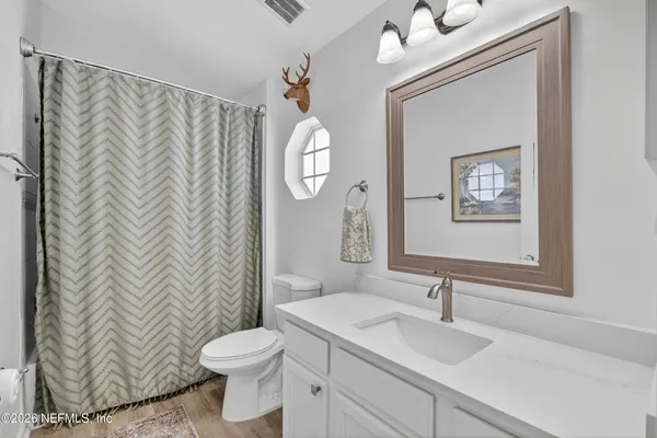 a bathroom with a toilet a sink and a mirror