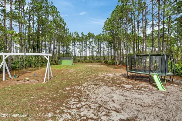 a backyard of a house with barbeque oven table and chairs