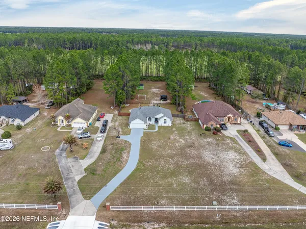 an aerial view of a house with a yard and lake view