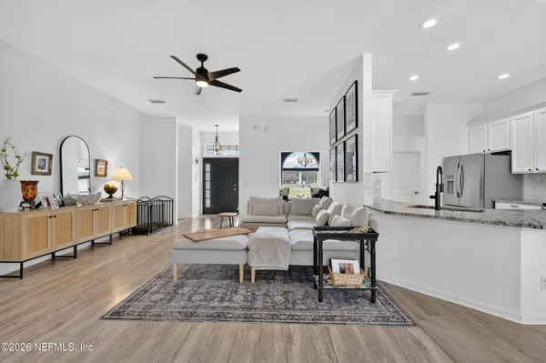 a living room with furniture and kitchen view