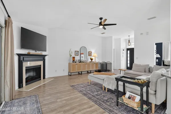 a living room with furniture a flat screen tv and a fireplace