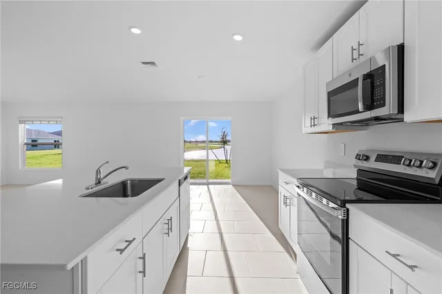 a kitchen with stainless steel appliances granite countertop a sink and a stove top oven