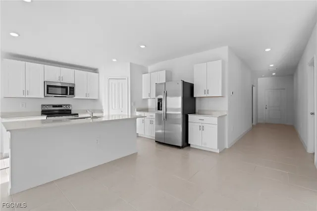 a kitchen with white cabinets and stainless steel appliances