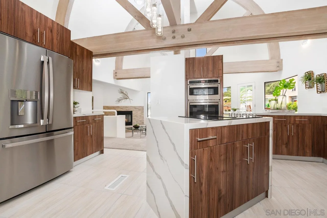 6105 Avenida Chamnez La Jolla, CA 92037 - Photo 14 of 59 a kitchen with stainless steel appliances kitchen island granite countertop a refrigerator a oven a sink with wooden cabinets and glass windows