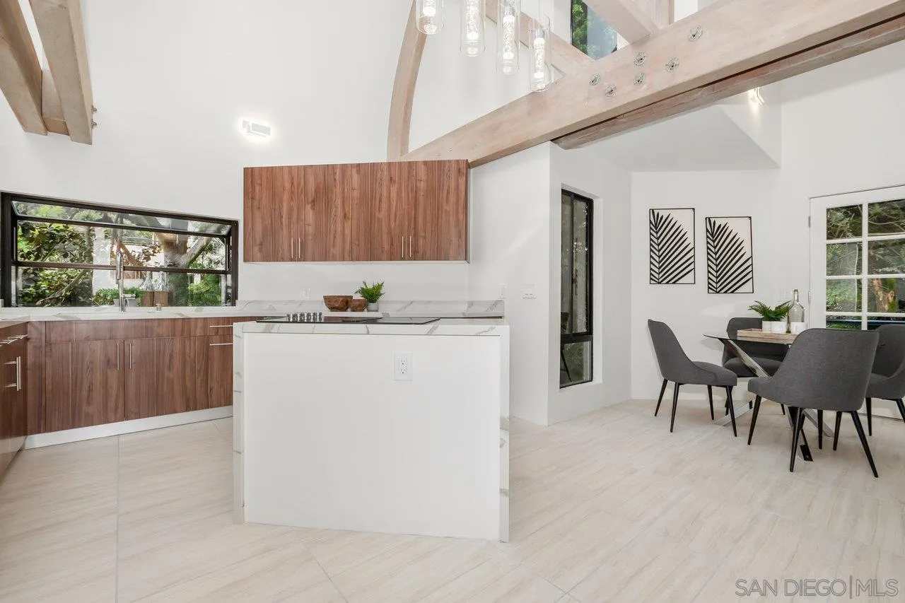 6105 Avenida Chamnez La Jolla, CA 92037 - Photo 15 of 59 a kitchen with kitchen island a stove a table and chairs in it