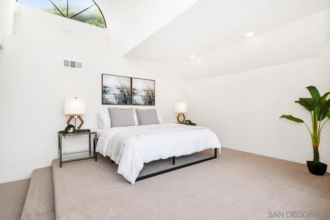 6105 Avenida Chamnez La Jolla, CA 92037 - Photo 30 of 59 a spacious bedroom with a bed and a potted plant