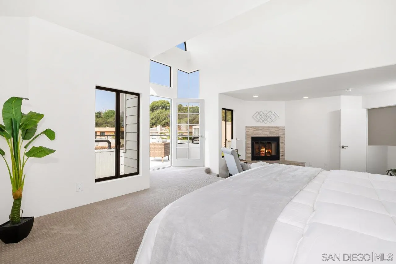 6105 Avenida Chamnez La Jolla, CA 92037 - Photo 31 of 59 a spacious bedroom with a large bed and a potted plant