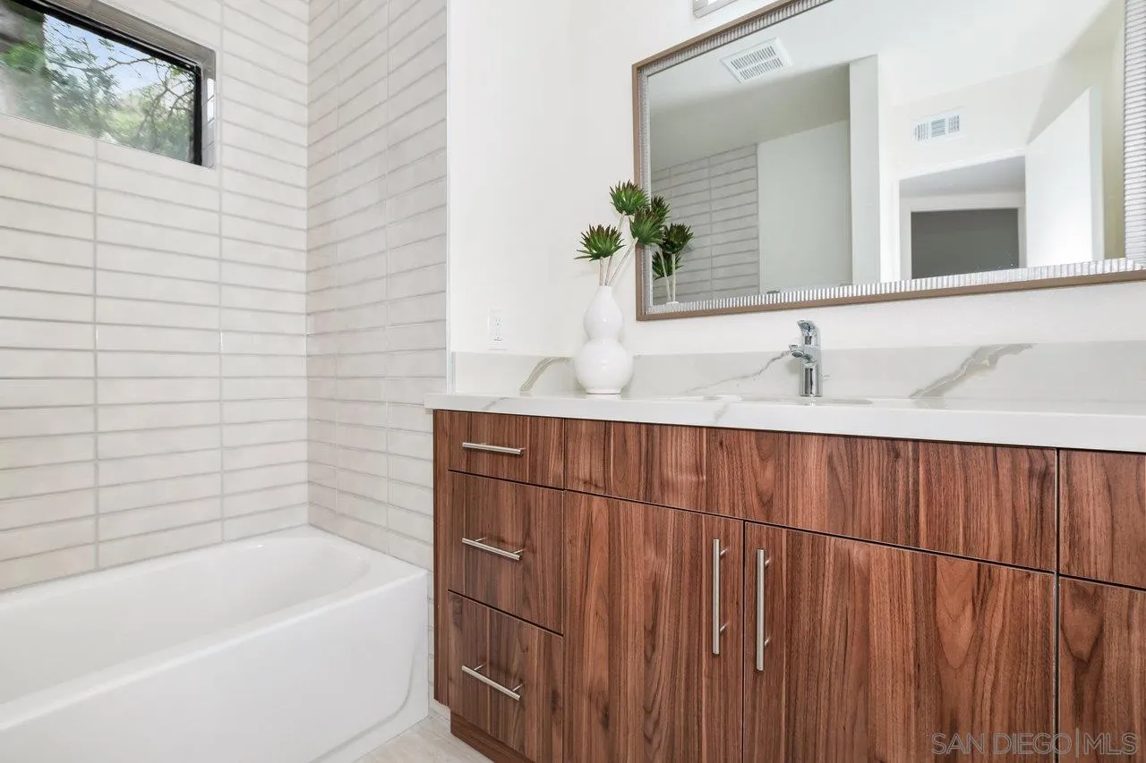 6105 Avenida Chamnez La Jolla, CA 92037 - Photo 42 of 59 a bathroom with a granite countertop sink and a bathtub