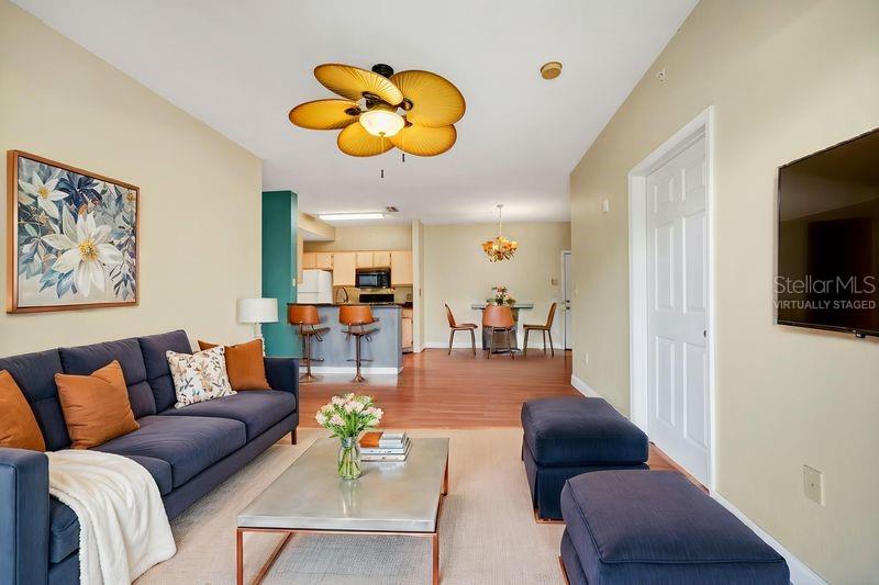 5471 Vineland Road, Unit 7301 Orlando, FL 32811 - Photo 11 of 34 a living room with furniture kitchen view and a flat screen tv