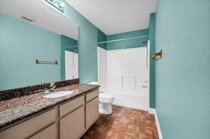 5471 Vineland Road, Unit 7301 Orlando, FL 32811 - Photo 19 of 34 a bathroom with a granite countertop sink toilet and shower