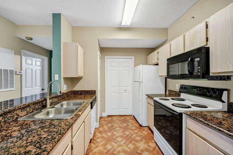 5471 Vineland Road, Unit 7301 Orlando, FL 32811 - Photo 3 of 34 a kitchen with stainless steel appliances granite countertop a sink stove and refrigerator