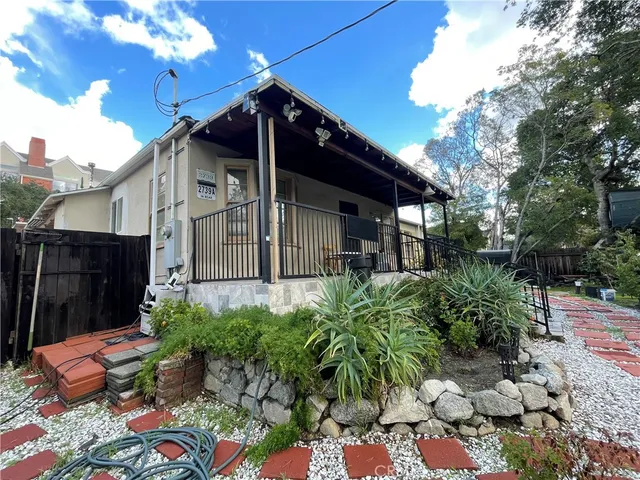a view of a chair and table in backyard of the house