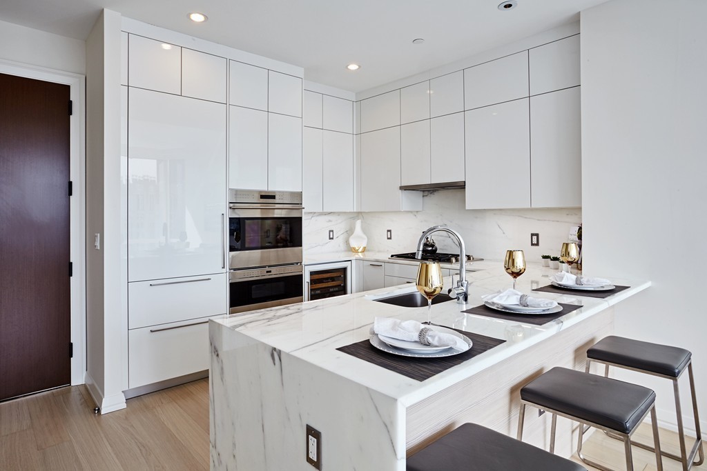 1 Franklin Street, Unit 3409 Boston, MA 02110 - Photo 4 of 18 a kitchen with a sink a stove and chairs