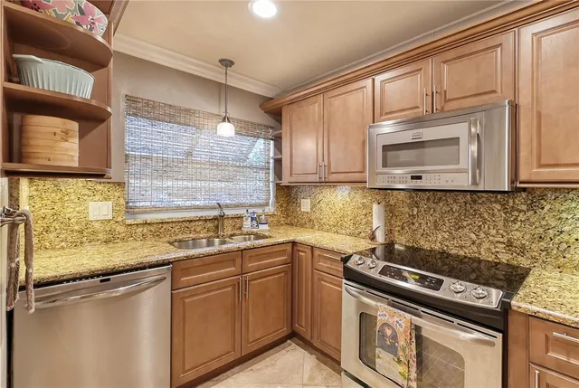 a kitchen with stainless steel appliances granite countertop a sink stove and microwave