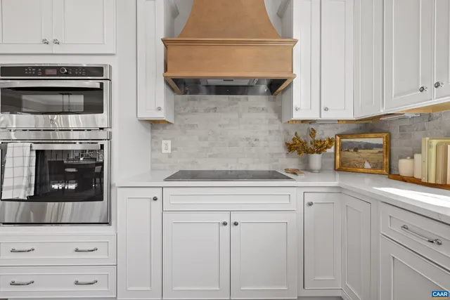 a kitchen with white cabinets and appliances