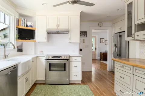a kitchen with white cabinets and white appliances