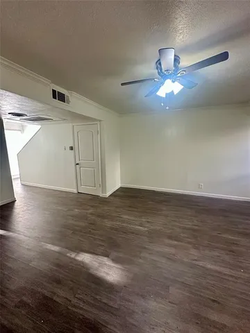 a view of a room with wooden floor and chandelier fan