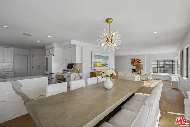 a dining room with wooden floor and chandelier