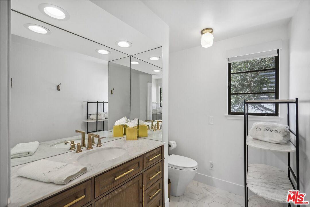 31500 Victoria Point Road Malibu, CA 90265 - Photo 38 of 53 a bathroom with a granite countertop sink mirror vanity and toilet