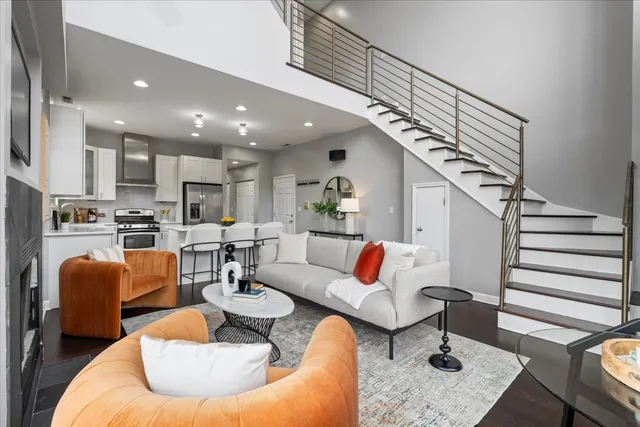 a living room with furniture kitchen view and a chandelier
