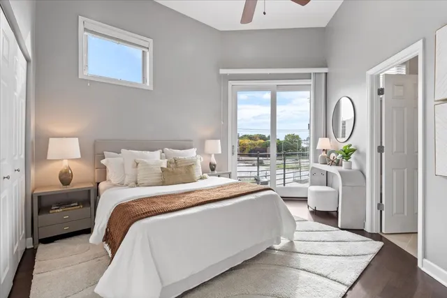 a bedroom with a bed a large window and a chandelier