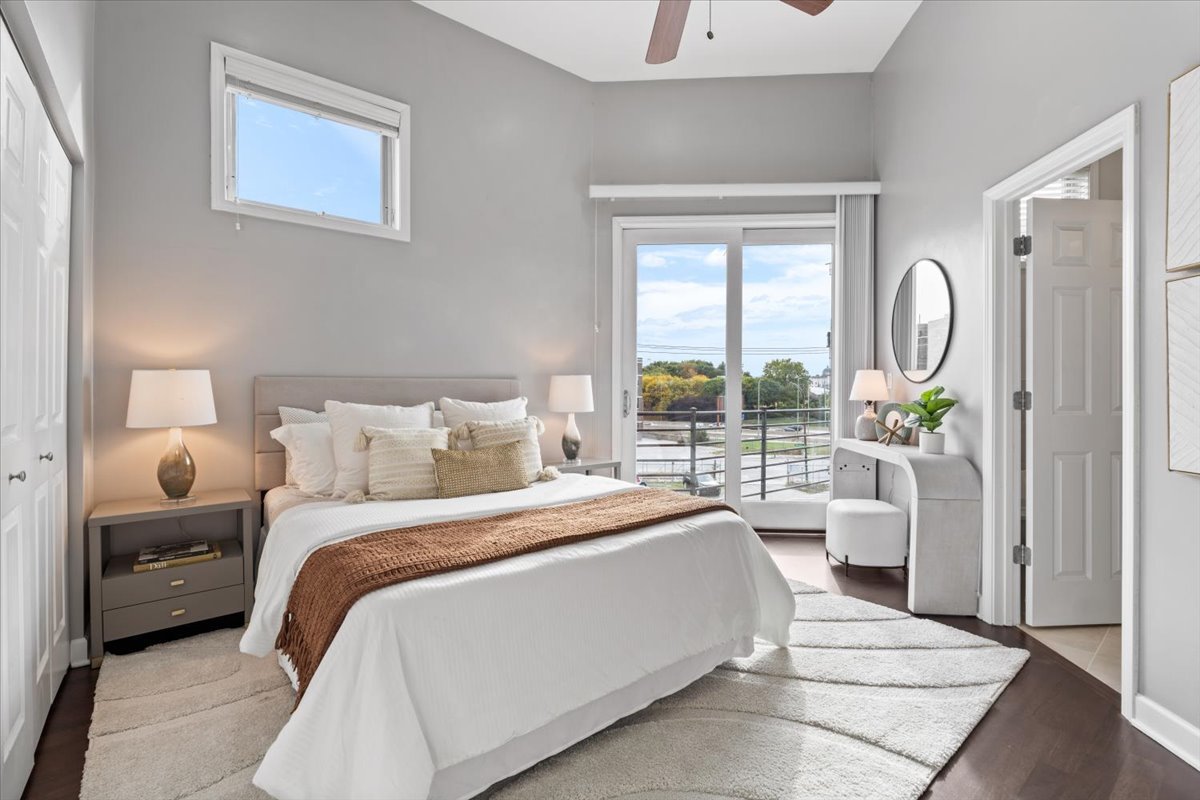 932 North Racine Avenue, Unit 2S Chicago, IL 60642 - Photo 16 of 29 a bedroom with a bed a large window and a chandelier