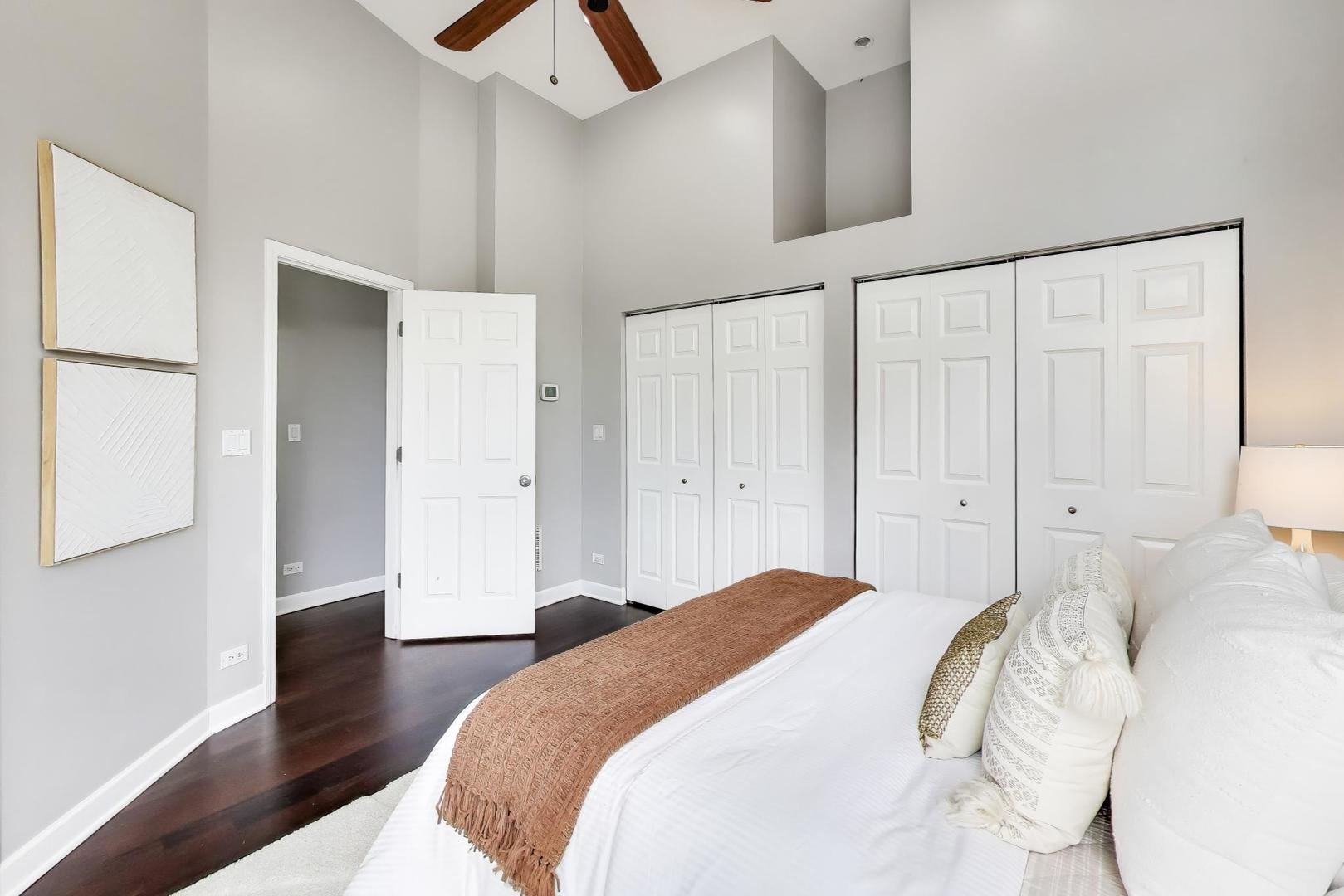 932 North Racine Avenue, Unit 2S Chicago, IL 60642 - Photo 17 of 29 a bedroom with a bed and a chandelier