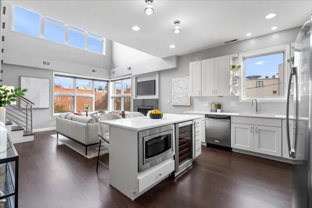 a kitchen that has a lot of white cabinets and wooden floor