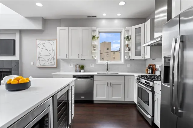 a kitchen with stainless steel appliances a stove a sink and a refrigerator