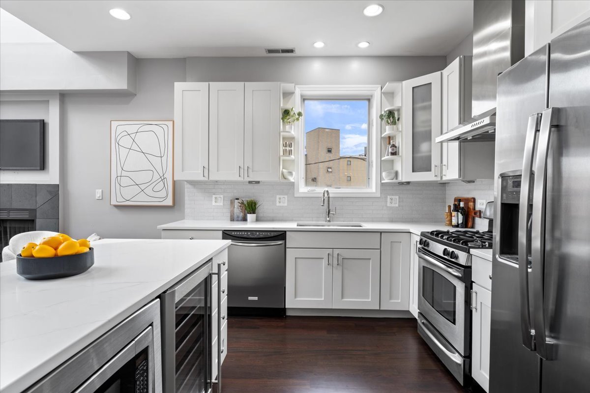 932 North Racine Avenue, Unit 2S Chicago, IL 60642 - Photo 3 of 29 a kitchen with stainless steel appliances a stove a sink and a refrigerator