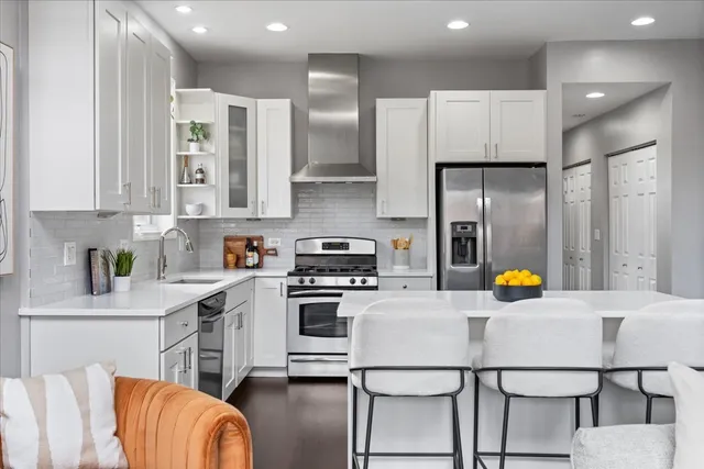 a kitchen with stainless steel appliances a refrigerator and a stove top oven