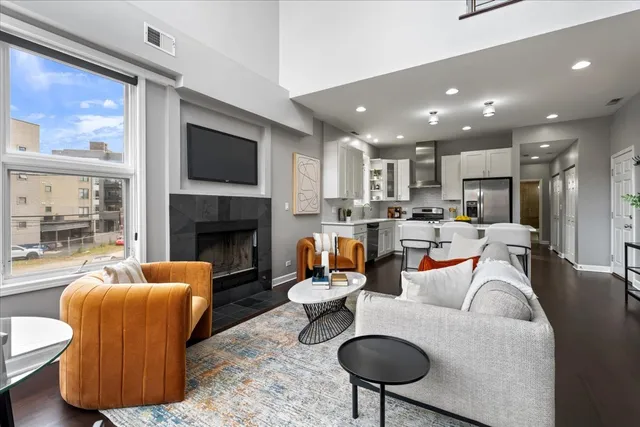 a living room with furniture a fireplace and a large window