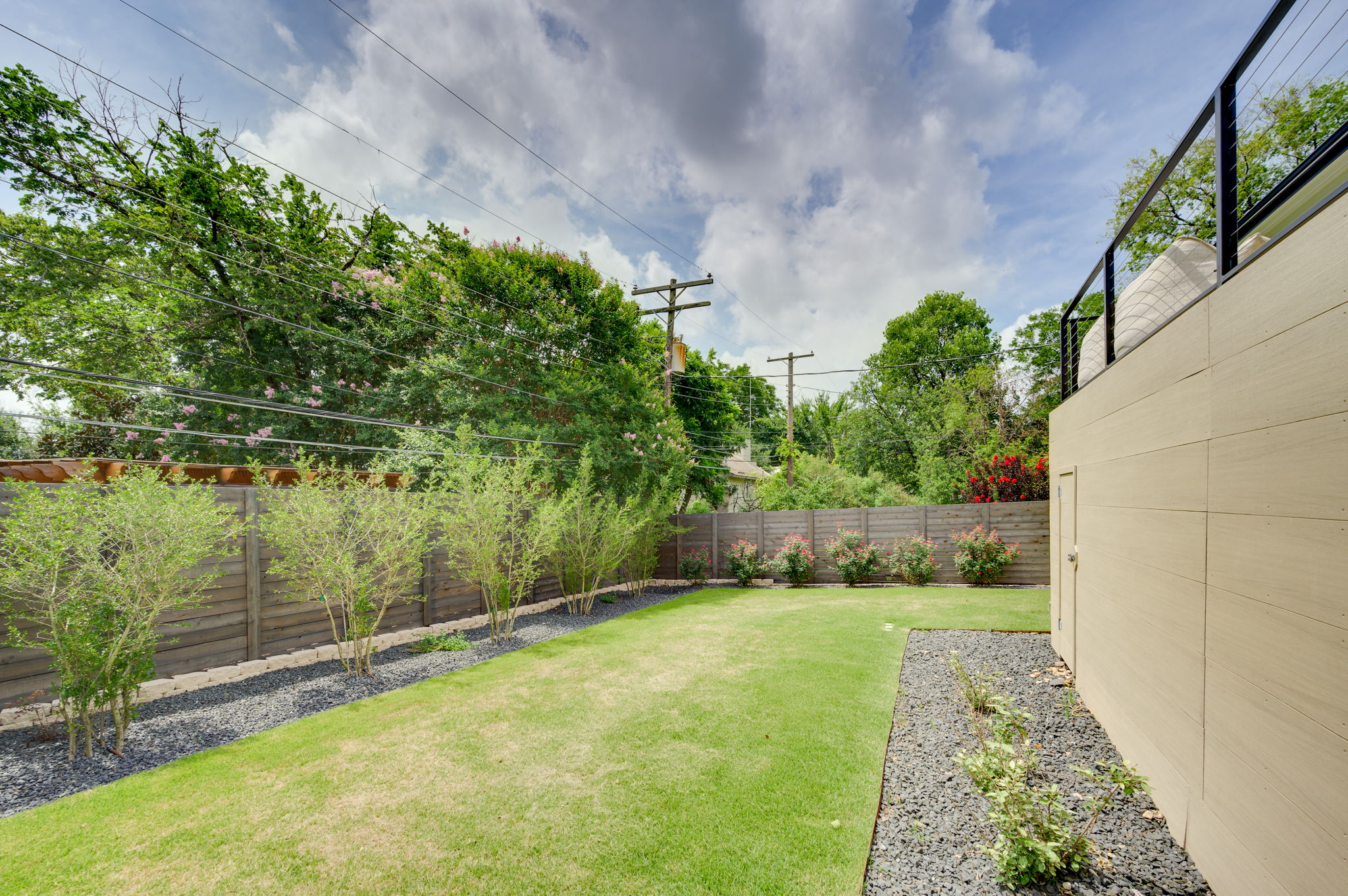 2415 McCall Road Austin, TX 78703 - Photo 40 of 40 A verdant lawn bordered by natural fencing, offering a private outdoor sanctuary.