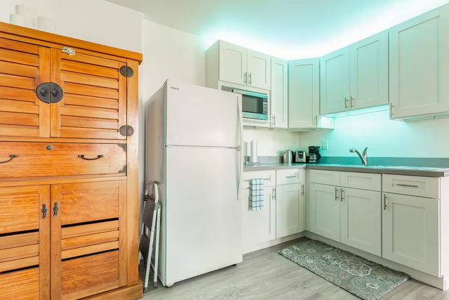 a kitchen with a refrigerator and white cabinets