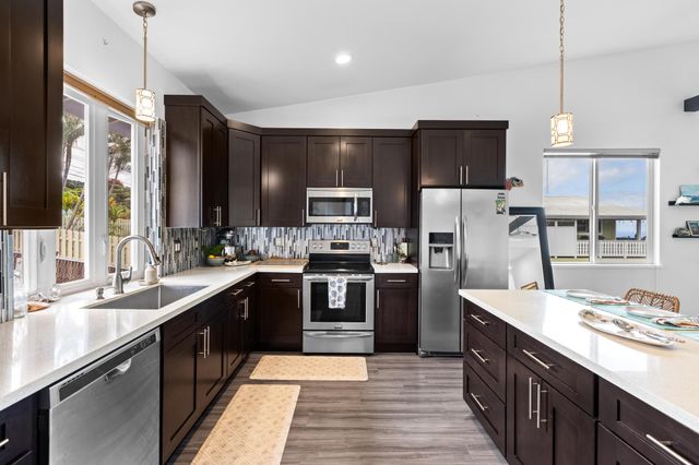 a large kitchen with a sink and stainless steel appliances