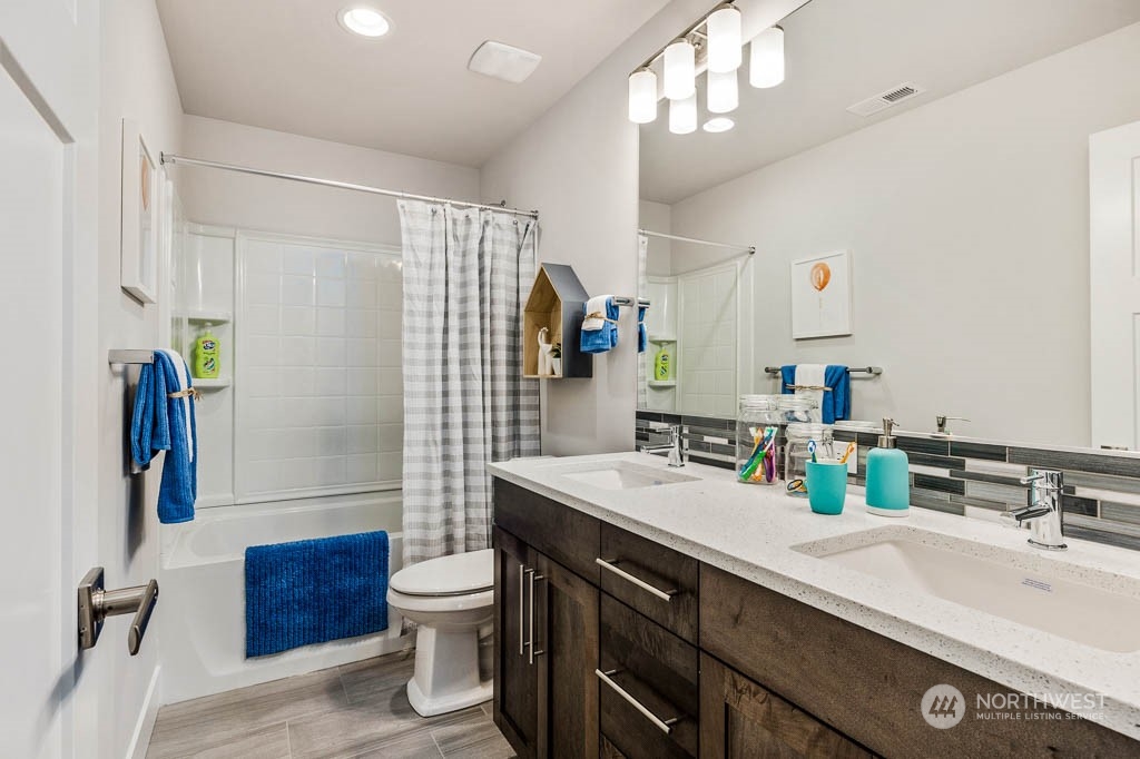 19 177th St S West Bothell, WA 98012 - Photo 24 of 29 a bathroom with a double vanity sink toilet and a mirror