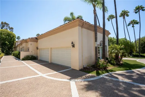 a view of a house with a yard and palm trees
