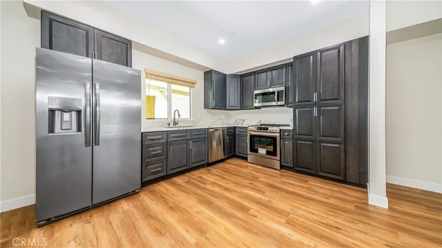 a kitchen with stainless steel appliances granite countertop a refrigerator and a stove top oven