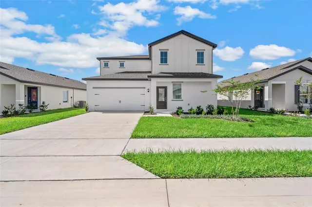 a front view of a house with a yard and garage