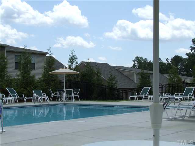 7803 Lillyhurst Drive Raleigh, NC 27612 - Photo 14 of 25 a view of a lake with table and chairs under an umbrella