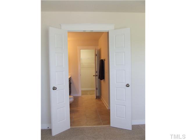 7803 Lillyhurst Drive Raleigh, NC 27612 - Photo 8 of 25 a view of a bathroom with a shower and a door