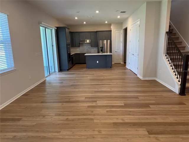 a kitchen with stainless steel appliances granite countertop a refrigerator and a stove top oven