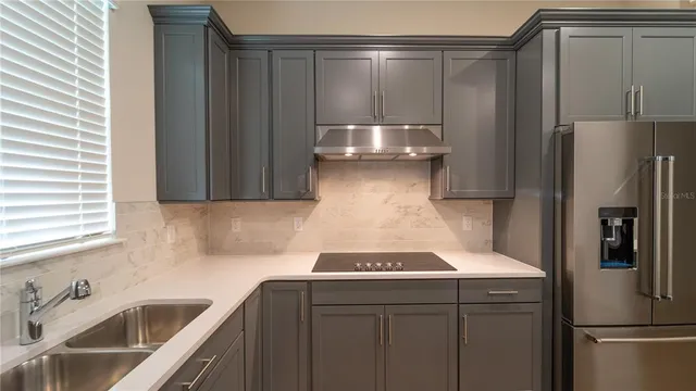 a kitchen with stainless steel appliances granite countertop a sink stove and cabinets