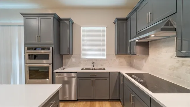 a kitchen with a sink a refrigerator and wooden cabinets