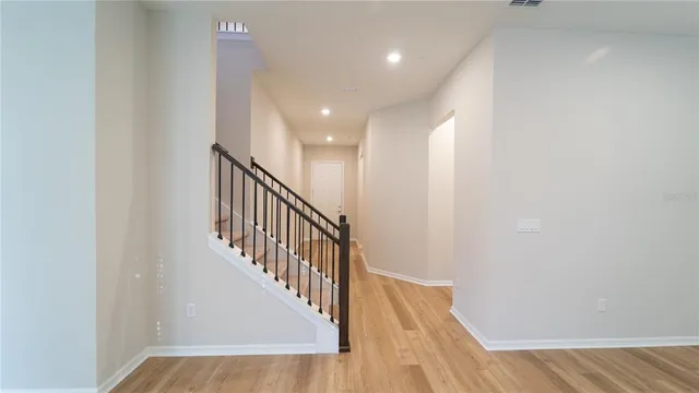 a view of staircase with railing and white walls