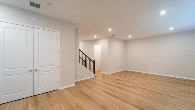 a view of an empty room with wooden floor