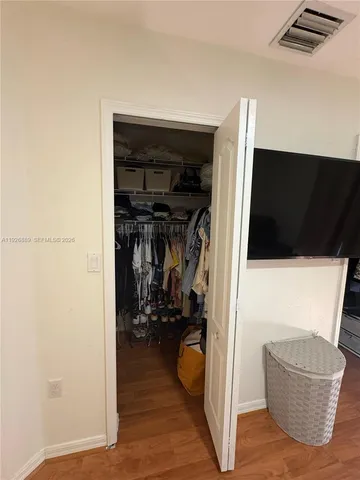 a view of walk in closet with clothes and shoes