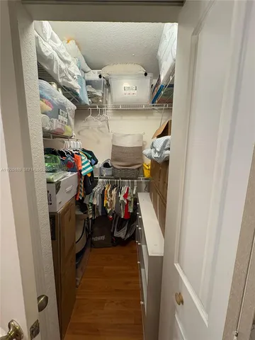 a view of walk in closet with clothes and shoes
